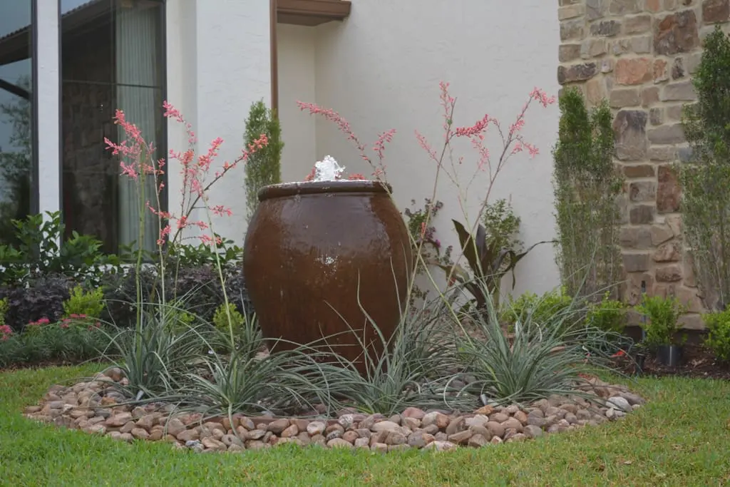 Urn fountain water feature with stone landscaping at AISD Showcase Home in The Woodlands by JM Outdoor Living