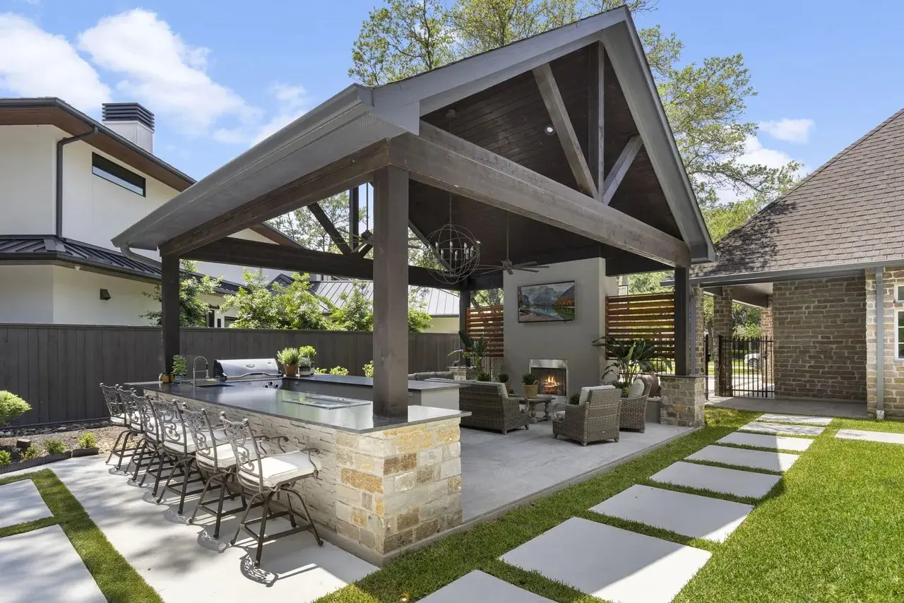 Heavy timber outdoor pavilion with outdoor kitchen and fireplace designed and built by JM Outdoor Living in The Woodlands, TX.