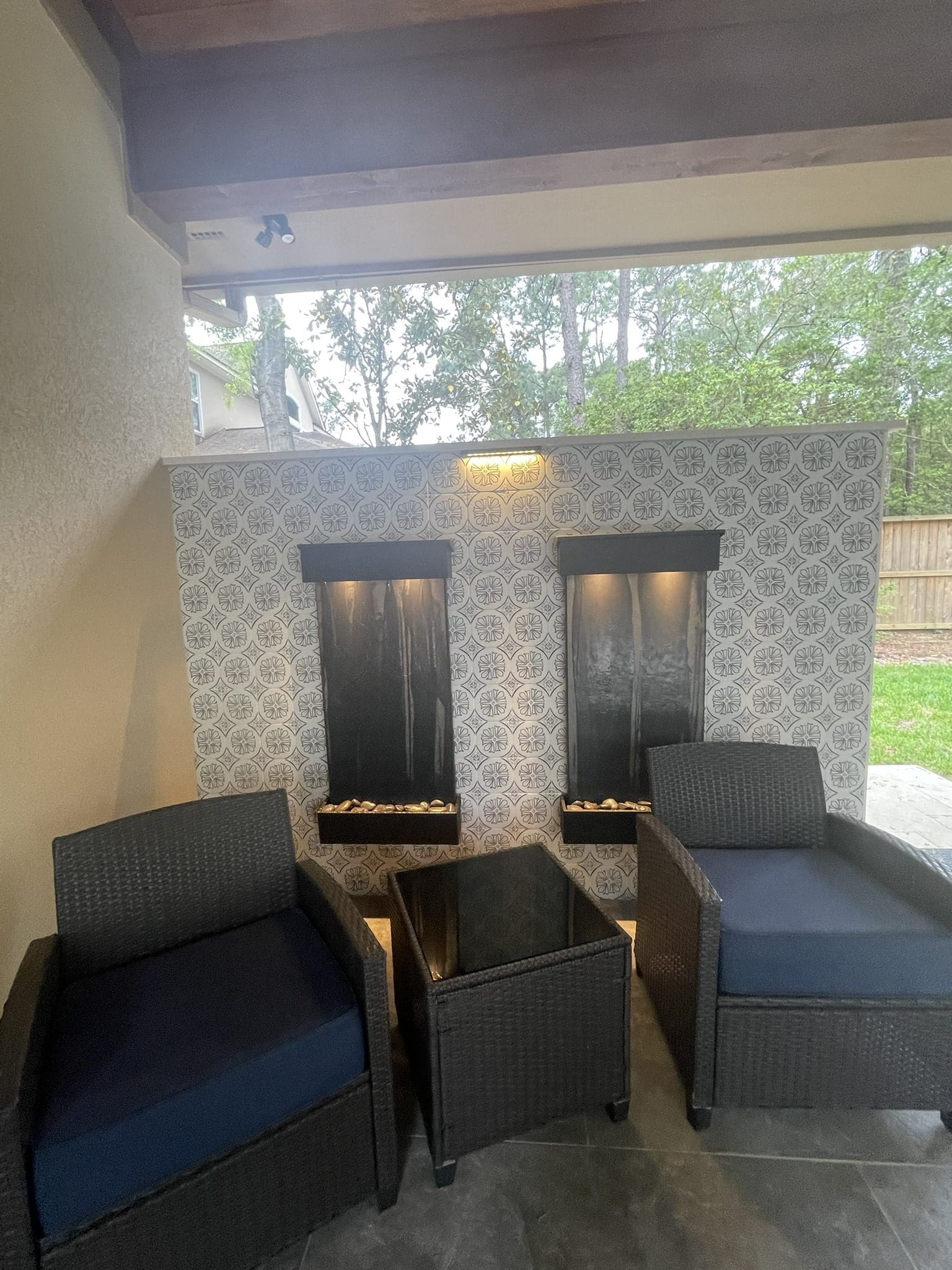 Modern water wall with patterned tile and patio seating area in The Woodlands, TX, designed by JM Outdoor Living.