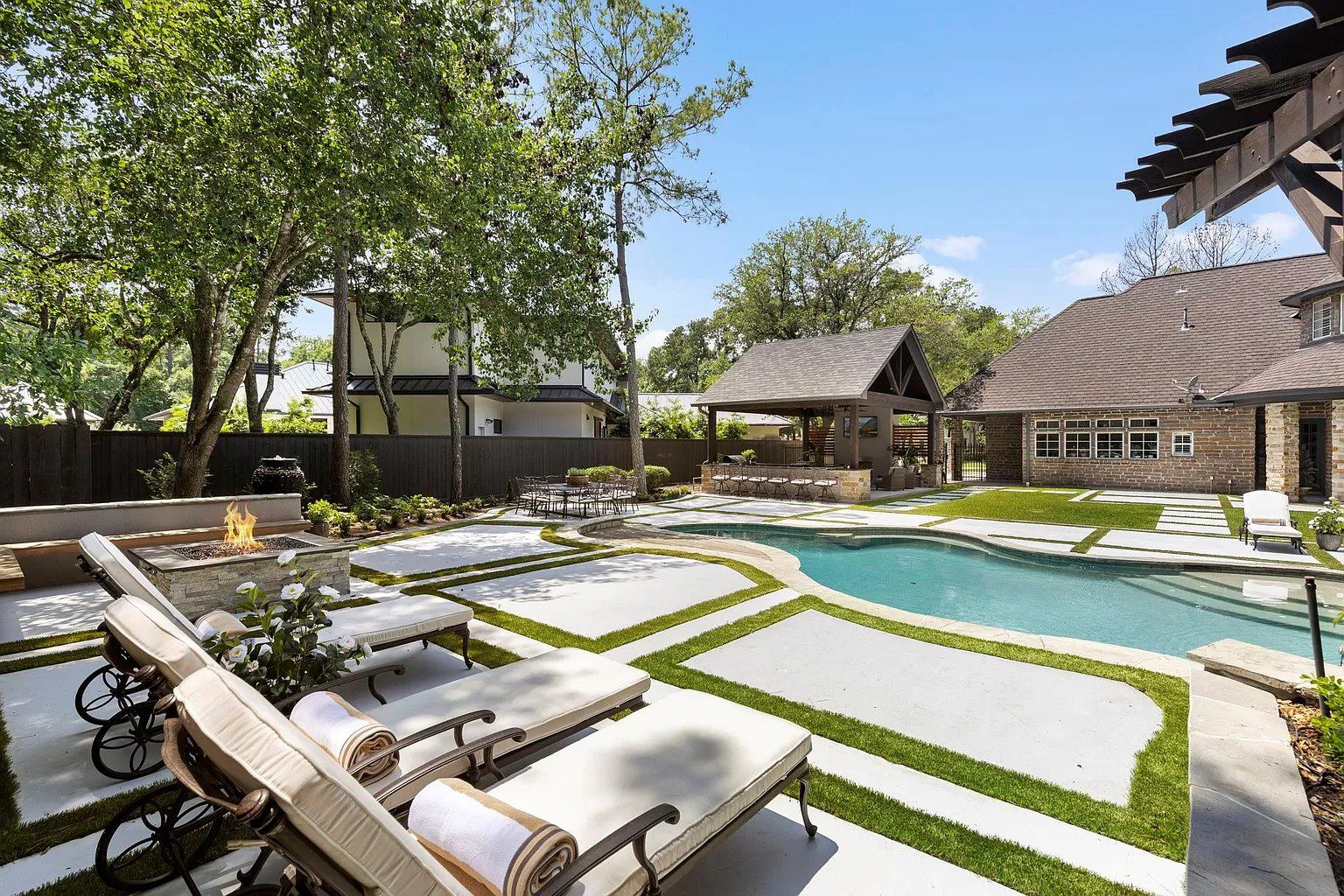 Luxury backyard transformation with custom pavilion, outdoor kitchen, pool remodel, fire feature, and landscape design by JM Outdoor Living in The Woodlands, TX.