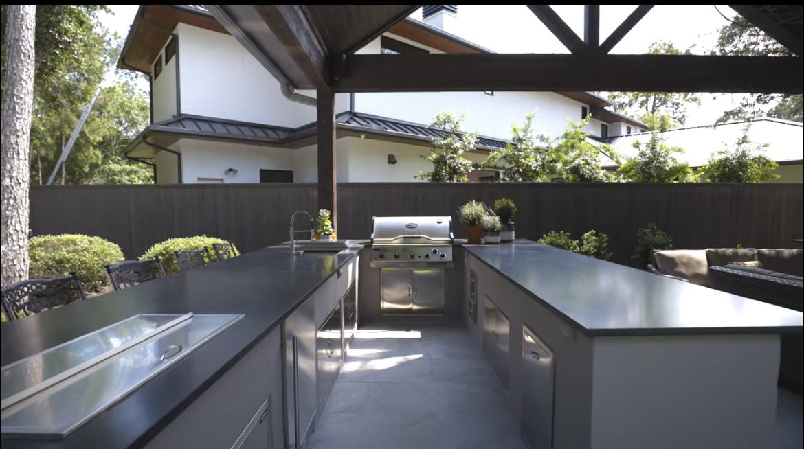 Luxury outdoor kitchen with stainless steel appliances and stone countertops by JM Outdoor Living in The Woodlands, Texas.